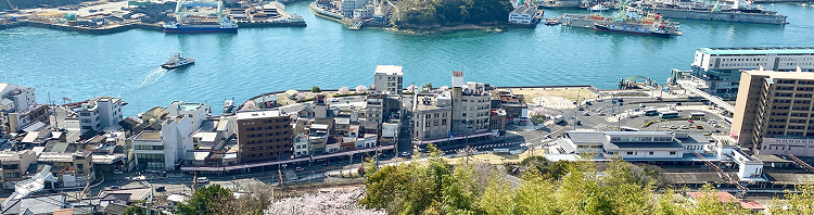 背景画像:尾道を上から見下ろした風景、海や街並みが写っています