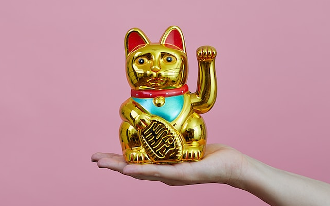 手の平に金色の招き猫が乗っています