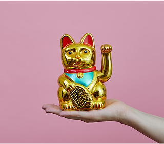 手の平に金色の招き猫が乗っています