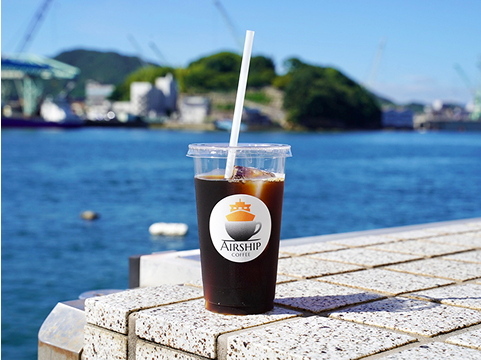 写真:海を背景にアイスコーヒーが写っています